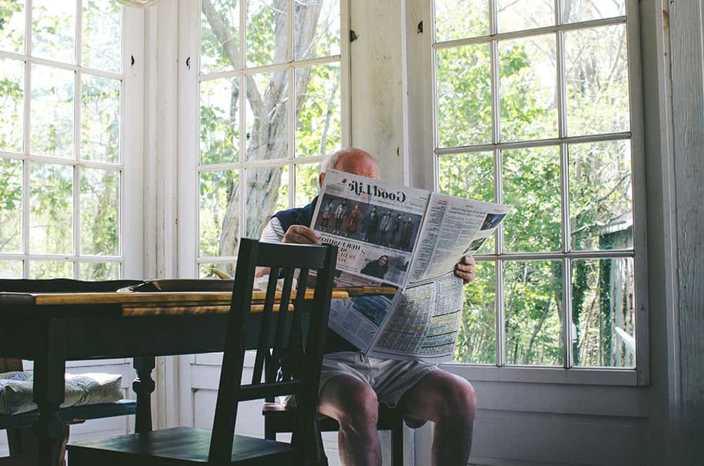 Man reading newspaper image