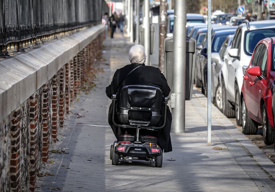 Mobility scooter user on pavement image