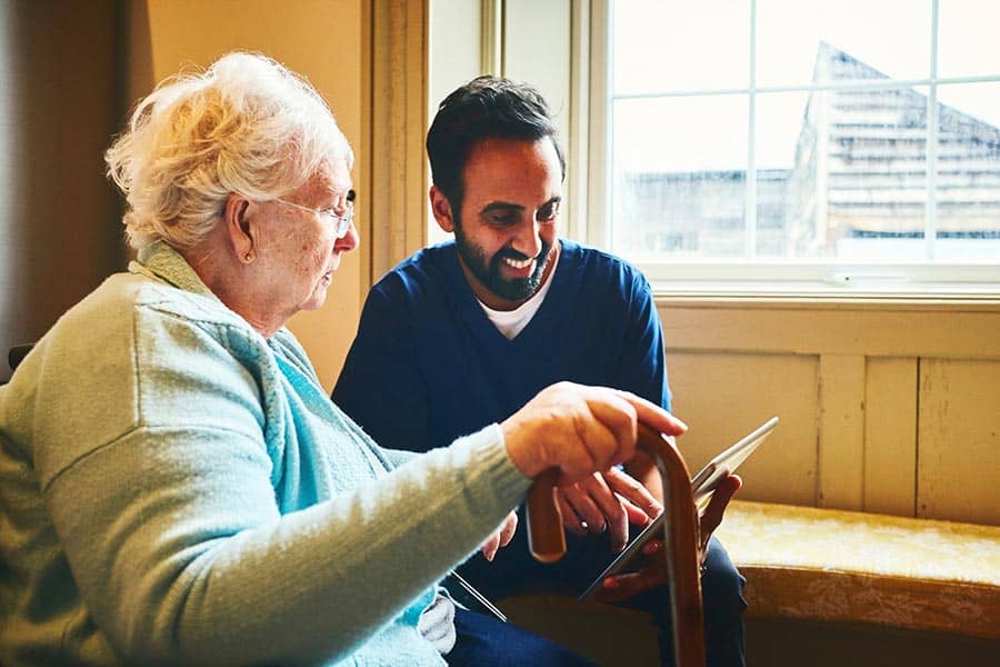 Older woman and care worker using tablet image